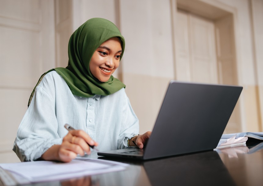 A teacher uses a laptop to complete an exam feedback survey.